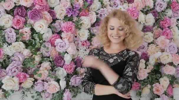 Frau blickt auf den Rahmen in der Nähe von Blumen — Stockvideo