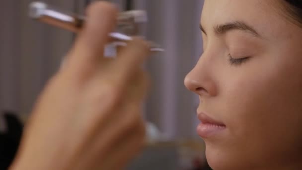 Woman applies airbrush concealer — Stock Video