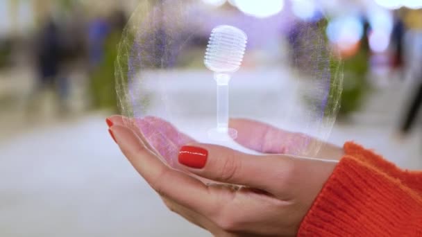 Manos femeninas sosteniendo holograma con micrófono — Vídeos de Stock