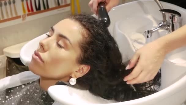 Hairdresser washes female hair — Stock Video