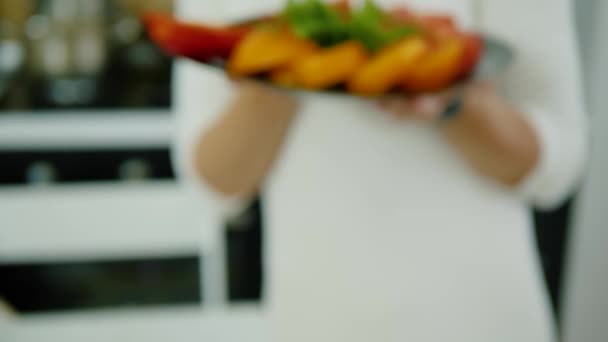 Las manos femeninas sostienen el plato de verduras en rodajas — Vídeos de Stock