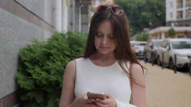 Çilli gülümseyen kız akıllı telefon kullanıyor.