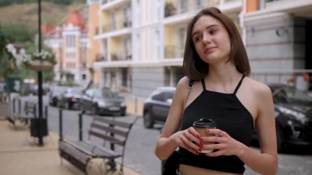 Счастливая девушка держит бумажный стаканчик — стоковое видео