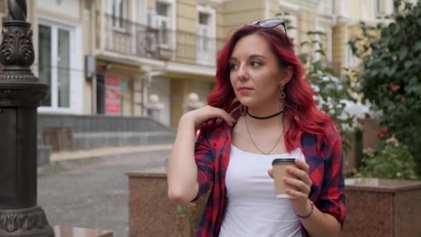Vörös hajú lány kezében egy papírpohár — Stock videók