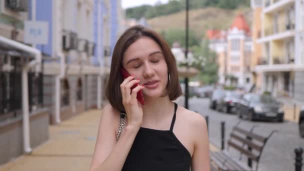 Menina bonito fala em um telefone vermelho — Vídeo de Stock