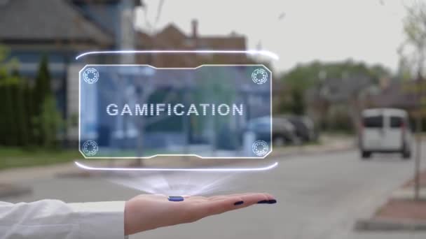 Женская рука показывает голограмму Gamification — стоковое видео