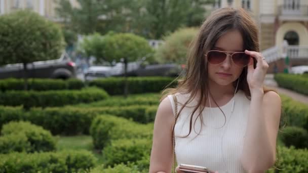 Mujer joven se quita las gafas de sol — Vídeos de Stock