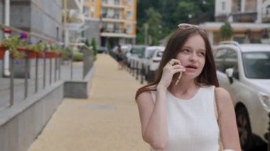Çilli gülümseyen kız telefonla konuşuyor.