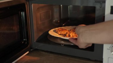 Mikrodalga fırında ısıtma işlemi. Erkek el çabuk pişirir, yemek ısıtmak için zaman kazandırır.