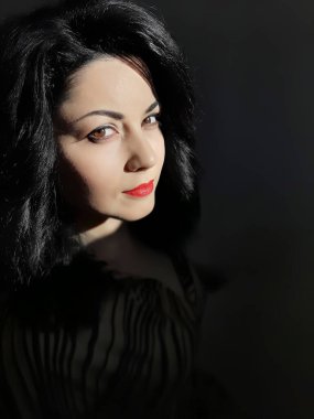 Genç, lüks esmer, kırmızı dudakları camdan gelen zıt ışıkta.