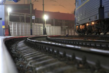 Metal raylar, Kiev tren istasyonunun bölgesinde duran bir tren vagonunun arka planına çarpıyor.