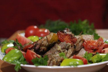 Sebze ve otlarla dolu tabakta ızgara hazır domuz eti.