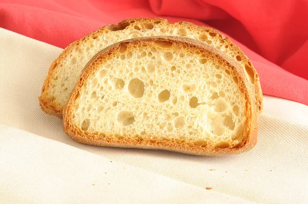 Two slices of fresh Italian bread, with tasty brown crust and crumb with large bubble