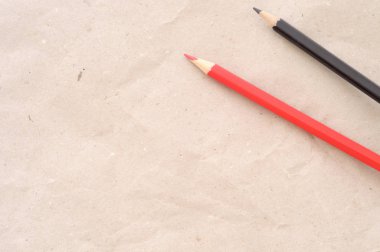 En az arka plan, kırmızı kalem ve siyah kalem kahverengi kağıt, yüksek açılı görünüş, büyük kopya alanı okula dönüş