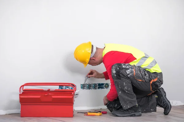 Eletricista no trabalho, renovação de casa, instalação elétrica, Mão de um eletricista, faz-tudo no trabalho — Fotografia de Stock