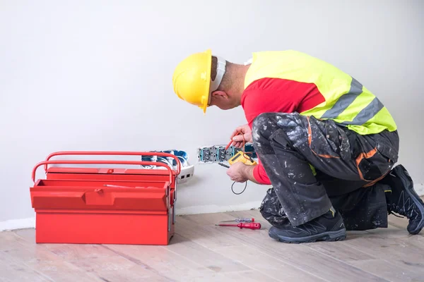 Eletricista no trabalho, renovação de casa, instalação elétrica, Mão de um eletricista, faz-tudo no trabalho — Fotografia de Stock