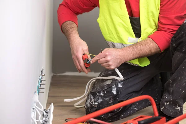 Eletricista no trabalho, renovação de casa, instalação elétrica, Mão de um eletricista, faz-tudo no trabalho — Fotografia de Stock