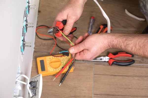 Eletricista no trabalho, renovação de casa, instalação elétrica, Mão de um eletricista, faz-tudo no trabalho — Fotografia de Stock