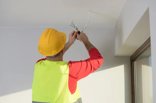 Eletricista no trabalho, renovação de casa, instalação elétrica, Mão de um eletricista, faz-tudo no trabalho — Fotografia de Stock