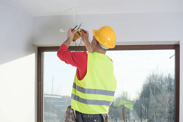 Eletricista no trabalho, renovação de casa, instalação elétrica, Mão de um eletricista, faz-tudo no trabalho — Fotografia de Stock