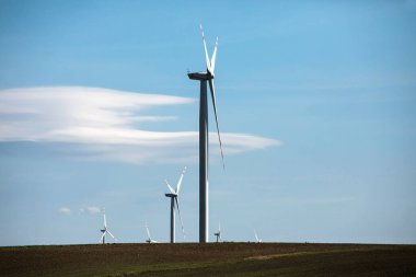Yeşil tepelerde rüzgar türbinleri, yeşil alanda elektrik üretimi için yel değirmenleri grubu.