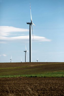Yeşil tepelerde rüzgar türbinleri, yeşil alanda elektrik üretimi için yel değirmenleri grubu.