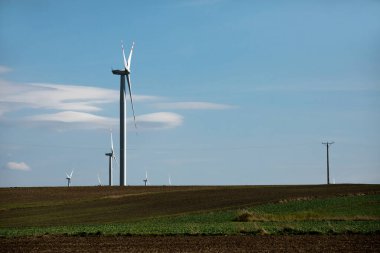 Yeşil tepelerde rüzgar türbinleri, yeşil alanda elektrik üretimi için yel değirmenleri grubu.