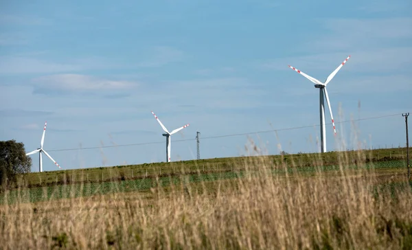 Větrné turbíny na zelených kopcích, Skupina větrných mlýnů pro výrobu elektrické energie v zelené — Stock fotografie