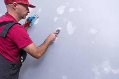 Ev ressamı, boyacı, ahşap merdiveni ve boş duvarı var.