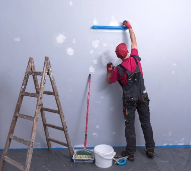 Ressam elinde bigudiyle iş başında.