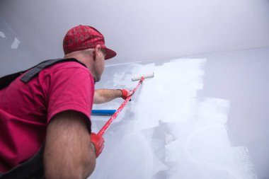 Ressam elinde bigudiyle iş başında.