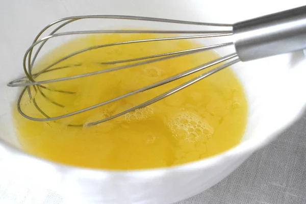 whisking eggs in a bowl with a whisk