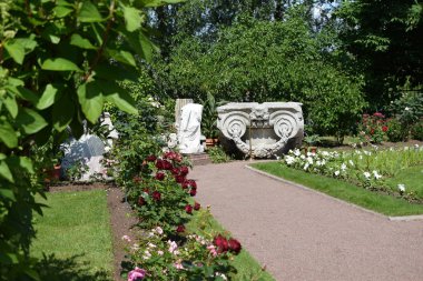 bahçede çiçekler ve yıkılan binanın elemanları, kalıntıları