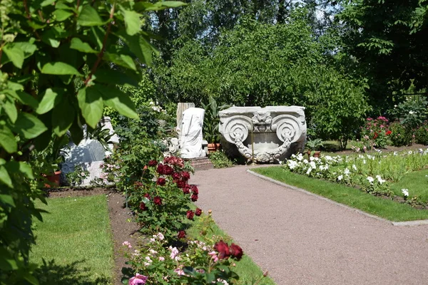 bahçede çiçekler ve yıkılan binanın elemanları, kalıntıları