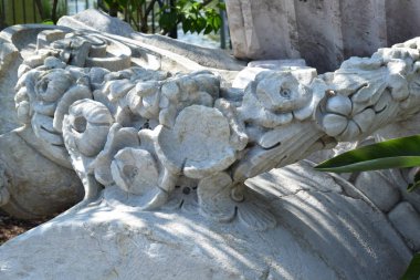 bahçede çiçek yatakları üzerinde çiçekler, yıkılmış binanın elemanları, bahçe peyzaj tasarımı