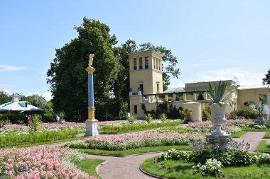 bahçede çiçek yatakları üzerinde çiçekler, yıkılmış binanın elemanları, bahçe peyzaj tasarımı