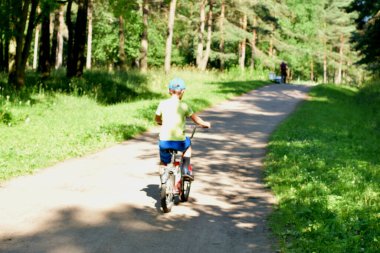 a child rides a bicycle in the park