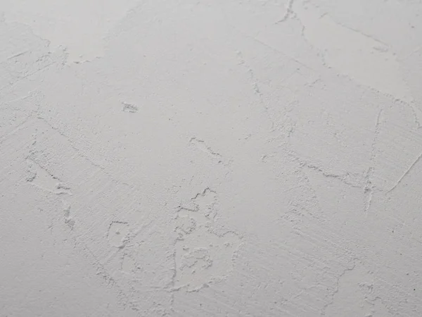 White abstract background or texture of concrete wall with rough stucco. Textured damaged plaster, loft style.