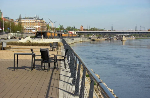 Table and chairs by the river in the city. — Stock Photo, Image