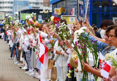 Minsk, Belarus - 22 Ağustos 2020. Barışçıl protestolar sırasında ellerinde çiçekler olan insanlar. Minsk, Belarus.