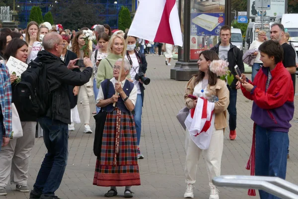 Minsk, Belarus - 29 Ağustos 2020. Kadınların büyük dayanışma yürüyüşü. Barışçıl protestolar sırasında elinde çiçekler olan bir kadın. Minsk, Belarus. Diktatör Lukashenko 'ya karşı protesto.