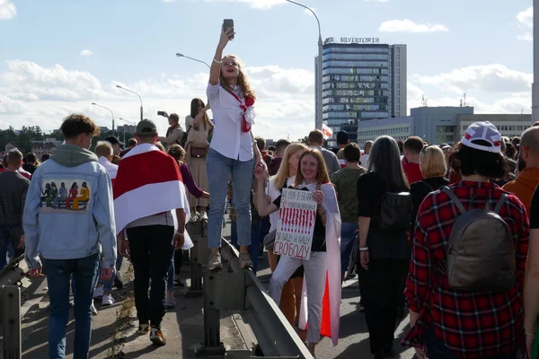 Minsk 'te polis hukuksuzluğuna ve Beyaz Rusya' daki cumhurbaşkanlığı seçimlerinin sahteciliğine karşı düzenlenen bir protestoda bayrakları, pankartları ve pankartları olan insanlar.