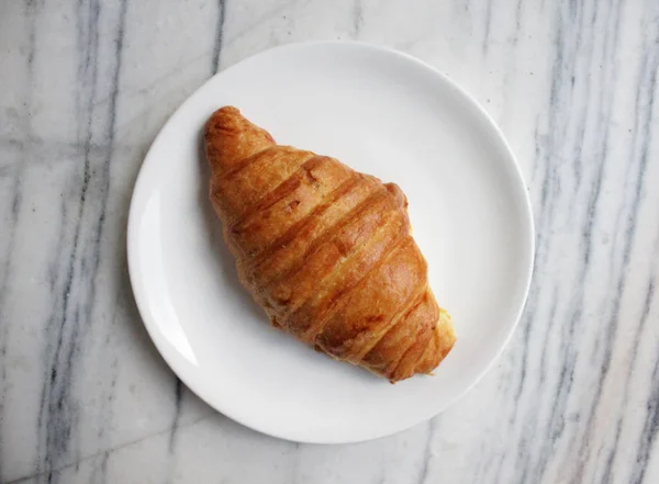 Food photography of french croissant on a white plate
