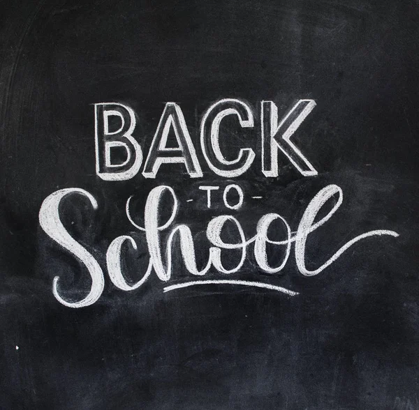 Back to school chalk lettering on blackboard background. Modern callygraphy photo.