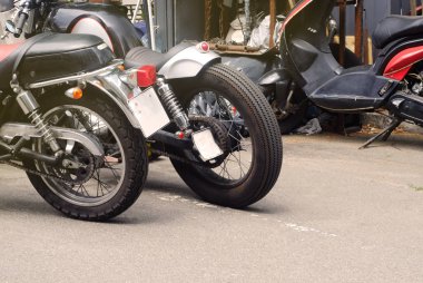 Retro vintage kauçuk tekerlekler ile motosikletler ve bisikletçileri toplama, motosiklet ve stil tema, benzin istasyonu, yakınındaki deri koltuklar standı