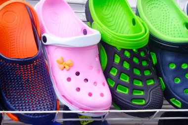 çok renkli kauçuk terlik yuvarlak delikler, Ayakkabı ve giysileri günlük yaşam için bir tema ile bir vitrin