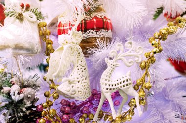 Beyaz arka plan beyaz bir Noel ağacı, Dekorotif oyuncakları ve Noel temalı bir geyik ile yeni yıl melek