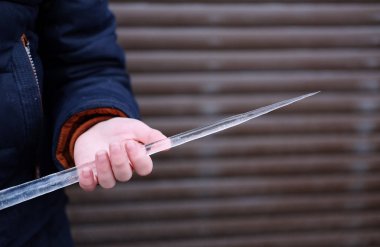 bir öğrenci onun elinde, güvenlik kış ve kışın yolda yaralanmaları konu uzun keskin bir saçağı tutar