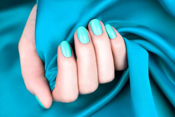 Mãos Femininas Com Manicure Hortelã Turquesa Fundo Turquesa — Fotografia de Stock