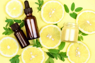 Doğal organik kozmetik. C vitamini içeren krem ve serum. Sarı arka plan..